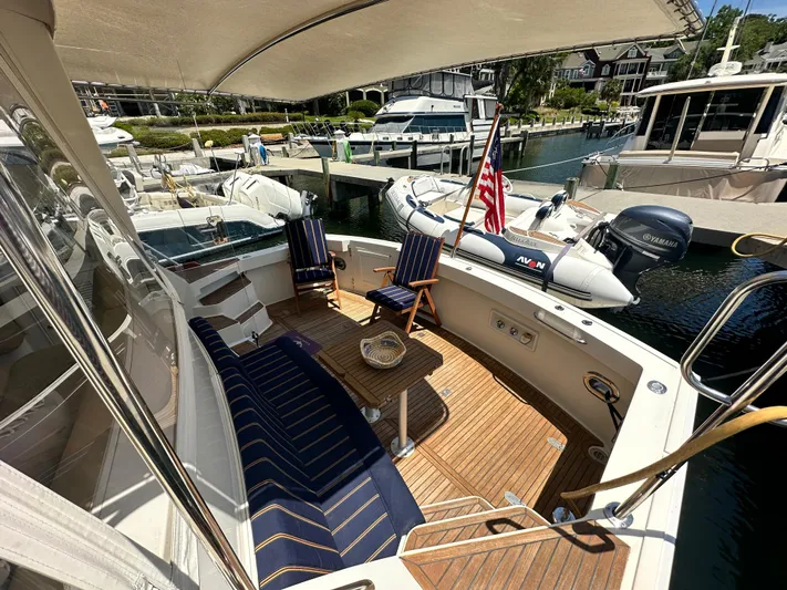 Bella Blue Yacht Photos Pics 2004 Grand Banks 49 Eastbay HX yacht with elegant deck seating and American flag at marina.