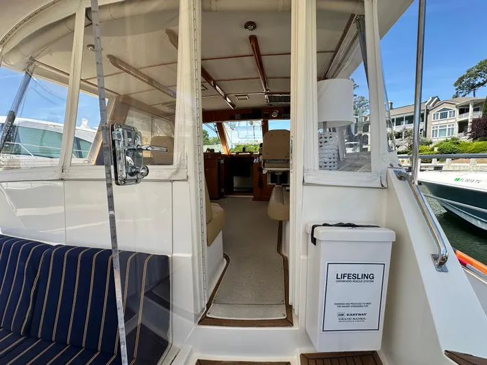 Bella Blue Yacht Photos Pics 2004 Grand Banks 49 Eastbay HX yacht interior with striped seating and lifesaving equipment.