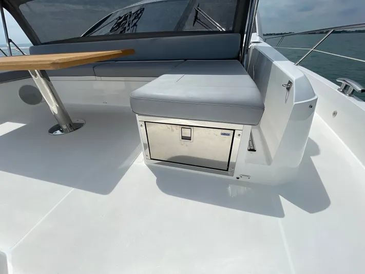 Almost Spoiled 1 Yacht Photos Pics Sunseeker 74 Sport Yacht 2020 deck with seating and table, featuring a built-in cooler.
