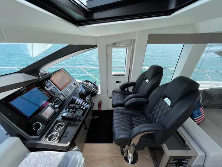 Almost Spoiled 1 Yacht Photos Pics Interior helm of 2020 Sunseeker 74 Sport Yacht with modern controls and leather seating.