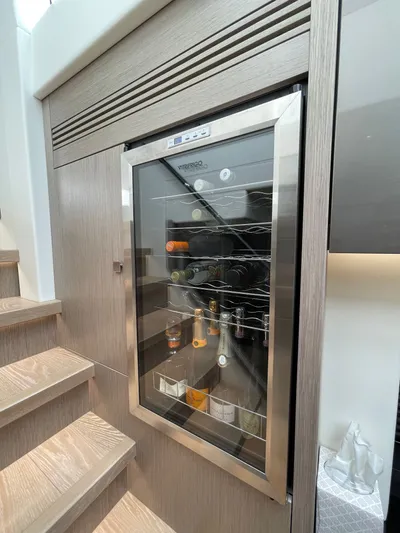 Almost Spoiled 1 Yacht Photos Pics Wine cooler on 2020 Sunseeker 74 Sport Yacht, integrated into wooden cabinetry.