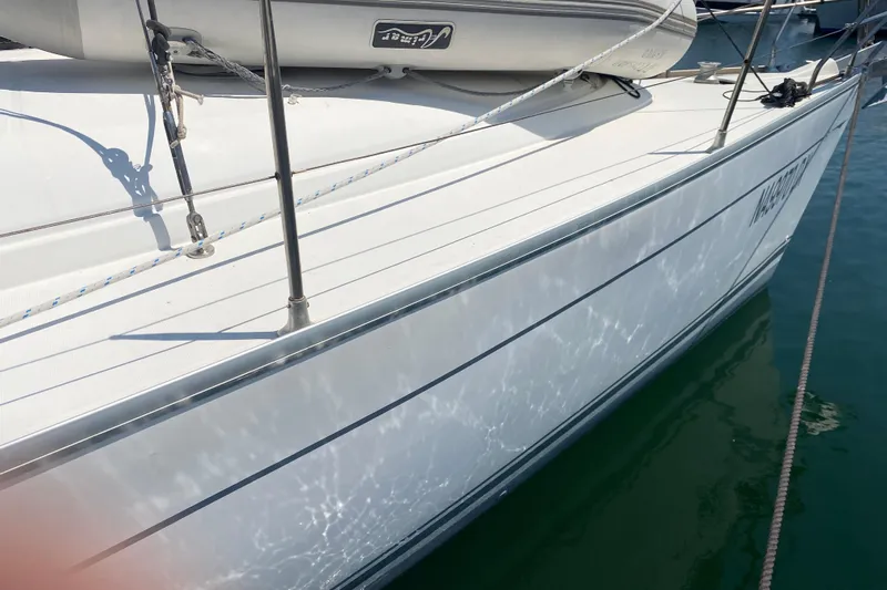  Yacht Photos Pics 2002 Jeanneau Sun Odyssey 40 sailboat docked, reflecting sunlight on calm water.