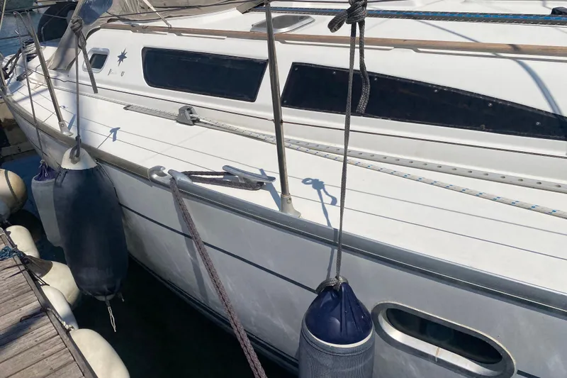  Yacht Photos Pics 2002 Jeanneau Sun Odyssey 40 sailboat docked with fenders, side view.