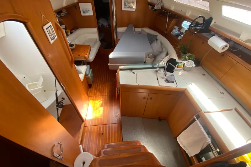  Yacht Photos Pics Interior of 2002 Jeanneau Sun Odyssey 40 sailboat with wooden flooring and cozy seating area.