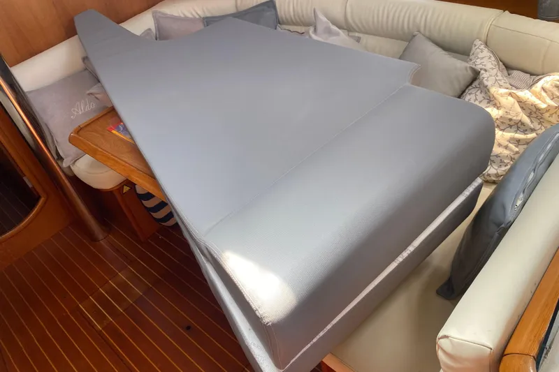  Yacht Photos Pics Interior of 2002 Jeanneau Sun Odyssey 40 with cushioned seating and wooden flooring.