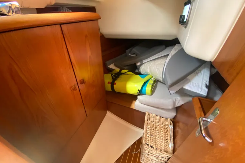  Yacht Photos Pics Interior storage area of a 2002 Jeanneau Sun Odyssey 40 sailboat with cushions and basket.