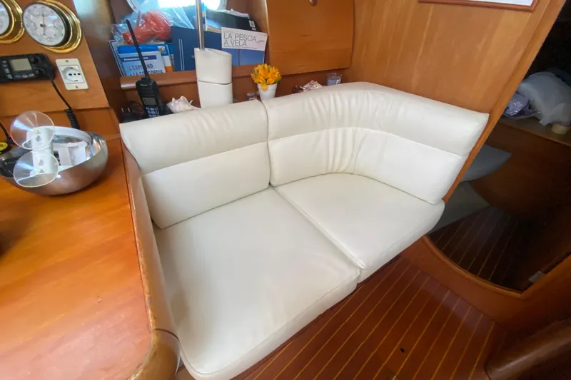  Yacht Photos Pics Cozy interior of 2002 Jeanneau Sun Odyssey 40 with white cushioned seating.