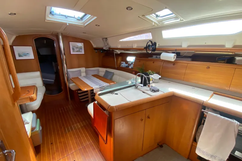  Yacht Photos Pics Interior of 2002 Jeanneau Sun Odyssey 40 yacht with wooden cabinetry and seating area.