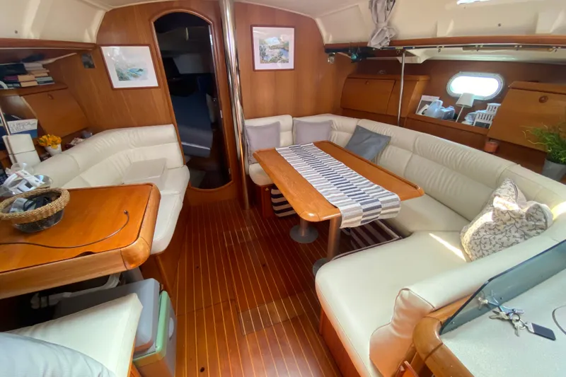  Yacht Photos Pics Interior of 2002 Jeanneau Sun Odyssey 40 yacht with elegant wood and white seating.