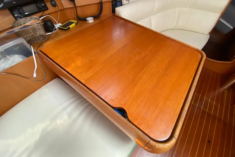  Yacht Photos Pics Wooden table and seating area inside a 2002 Jeanneau Sun Odyssey 40 sailboat.