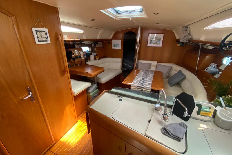  Yacht Photos Pics Interior of 2002 Jeanneau Sun Odyssey 40 sailboat with cozy seating and wooden finishes.