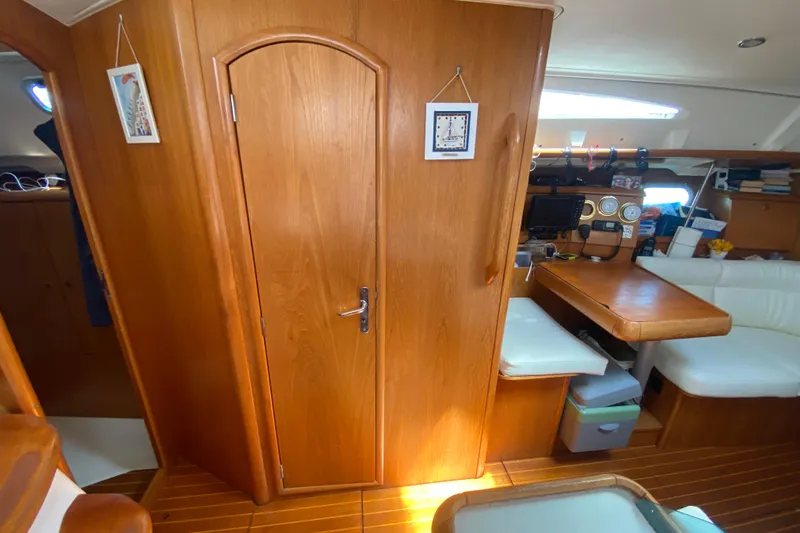  Yacht Photos Pics Interior of 2002 Jeanneau Sun Odyssey 40 sailboat with wooden finishes and seating area.