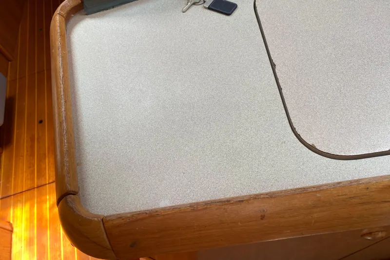  Yacht Photos Pics Interior of 2002 Jeanneau Sun Odyssey 40 yacht with wooden trim and keys on table.