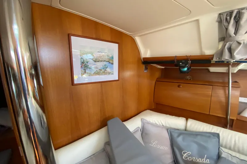  Yacht Photos Pics Interior of 2002 Jeanneau Sun Odyssey 40 yacht with wood paneling and cozy seating area.