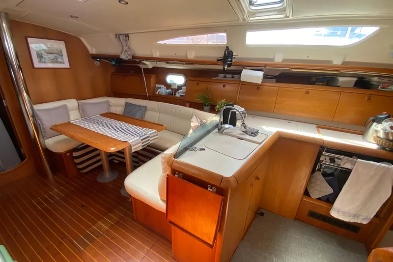  Yacht Photos Pics Interior of 2002 Jeanneau Sun Odyssey 40 yacht with cozy seating and wooden cabinetry.