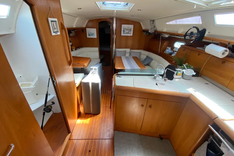  Yacht Photos Pics Interior of 2002 Jeanneau Sun Odyssey 40 sailboat with wood finish and cozy seating area.
