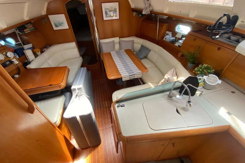  Yacht Photos Pics Interior of 2002 Jeanneau Sun Odyssey 40 yacht with cozy seating and wooden finishes.