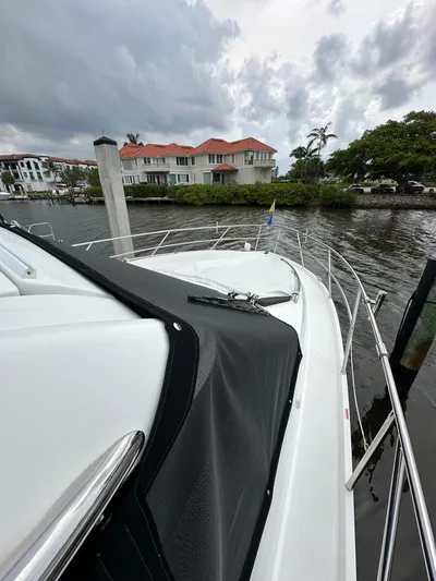 Stelyn Time Yacht Photos Pics 2021 Galeon 425HTS yacht docked near waterfront homes under cloudy skies.