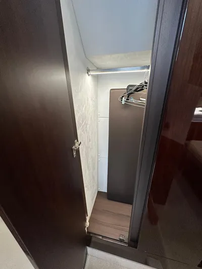Stelyn Time Yacht Photos Pics 2021 Galeon 425HTS yacht closet with hangers and dark wood finish.