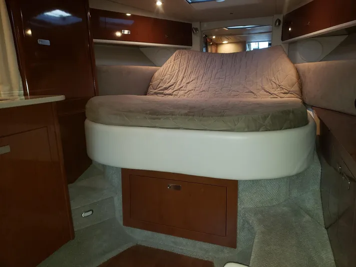 Sol Searching Yacht Photos Pics 2011 Sea Ray 350 Sundancer cabin interior with bed and wooden cabinetry.