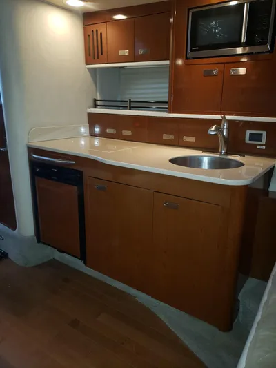 Sol Searching Yacht Photos Pics 2011 Sea Ray 350 Sundancer yacht kitchen with wood cabinets, sink, and microwave.