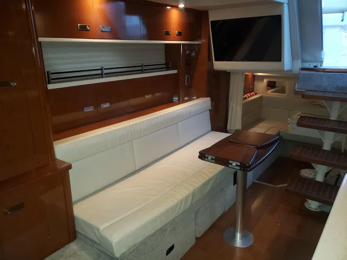 Sol Searching Yacht Photos Pics Interior of 2011 Sea Ray 350 Sundancer yacht with white seating and wooden accents.