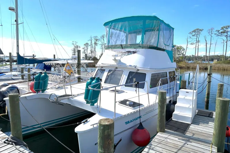 Seahawk Yacht Photos Pics 2004 PDQ 34 Power Catamaran docked at marina with clear blue sky.