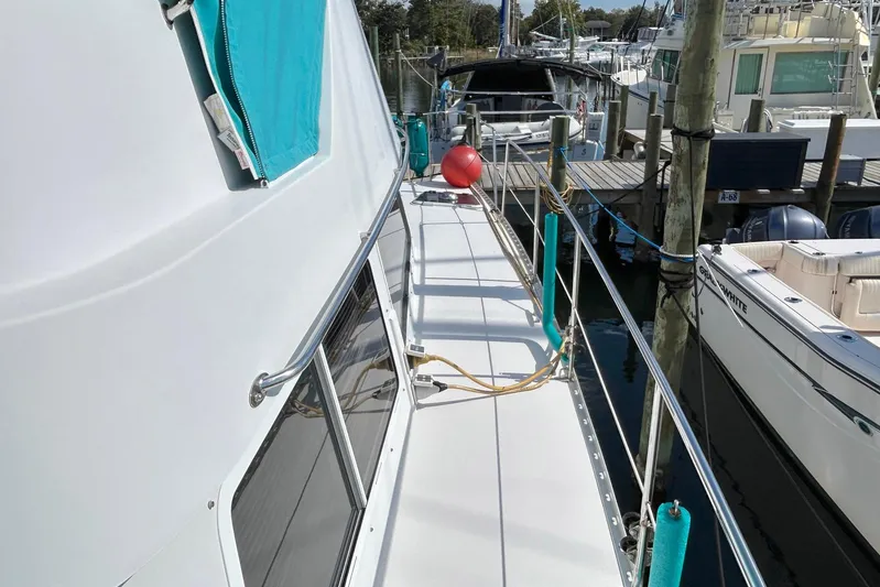 Seahawk Yacht Photos Pics 2004 PDQ 34 Power Catamaran docked, featuring a clean deck and vibrant teal accents.