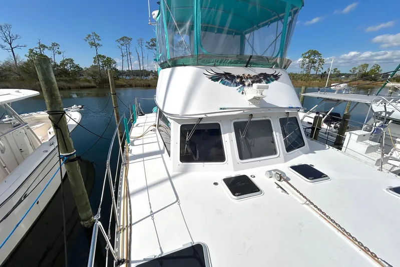 Seahawk Yacht Photos Pics 2004 PDQ 34 Power Catamaran docked, featuring a vibrant eagle design on the cabin.