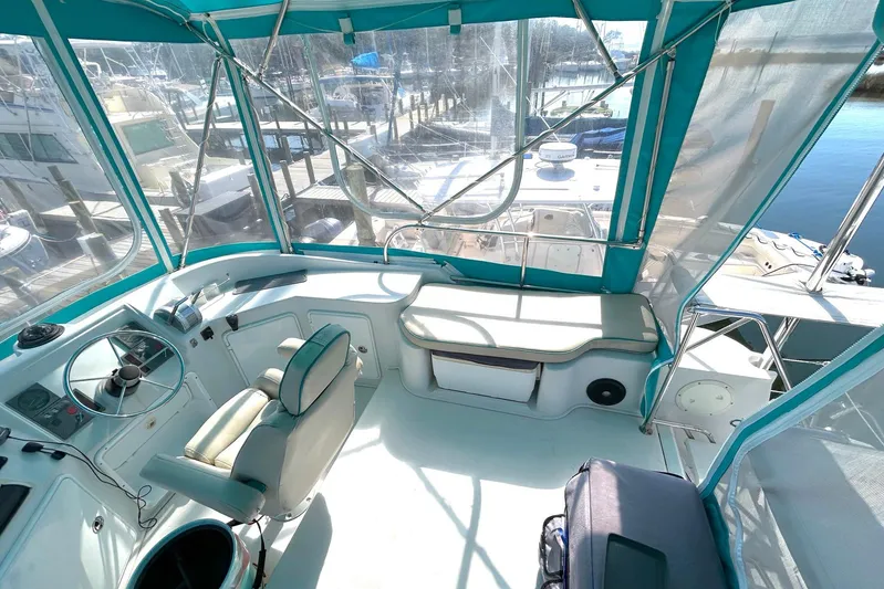Seahawk Yacht Photos Pics 2004 PDQ 34 Power Catamaran cockpit with teal canopy, steering wheel, and marina view.