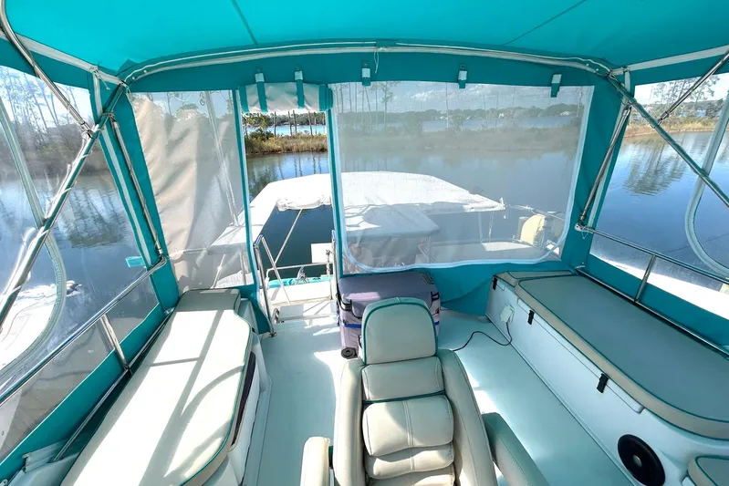 Seahawk Yacht Photos Pics 2004 PDQ 34 Power Catamaran interior with teal canopy and seating, docked by calm waters.