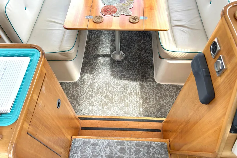 Seahawk Yacht Photos Pics 2004 PDQ 34 Power Catamaran interior with wooden table, cushioned seating, and patterned carpet.