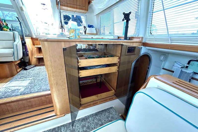 Seahawk Yacht Photos Pics Interior of 2004 PDQ 34 Power Catamaran with open wooden cabinet and seating area.