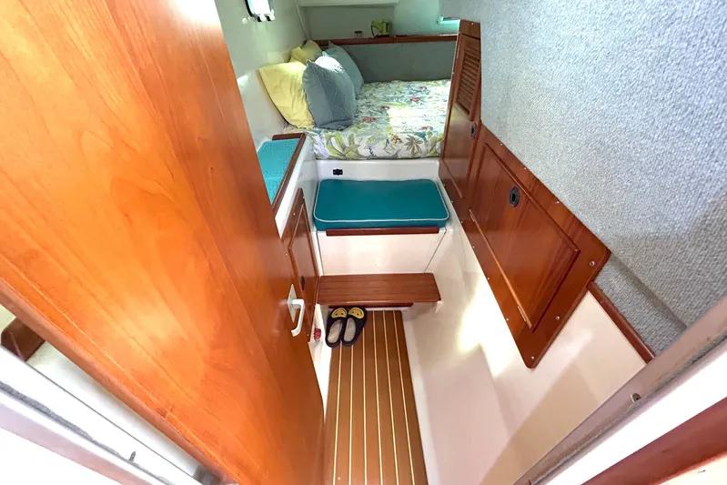 Seahawk Yacht Photos Pics Interior cabin of 2004 PDQ 34 Power Catamaran with cozy bed and wooden accents.
