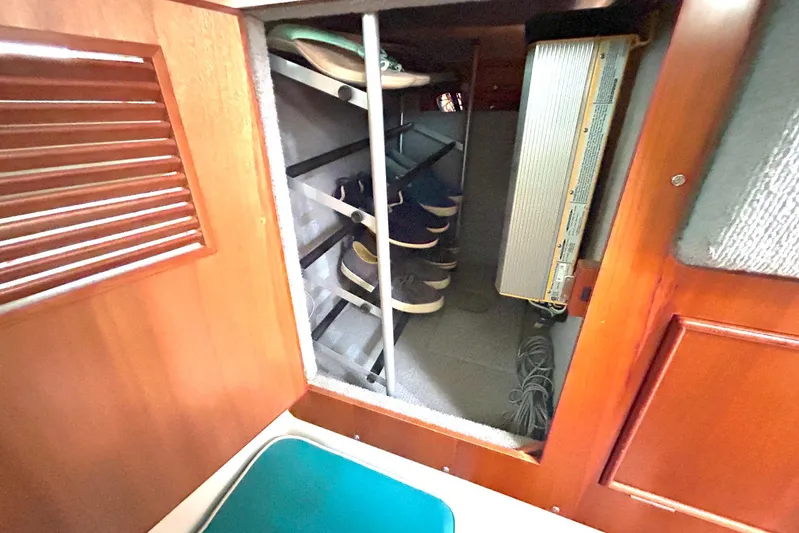Seahawk Yacht Photos Pics Interior shoe storage on 2004 PDQ 34 Power Catamaran, featuring wooden cabinetry and organized shelving.