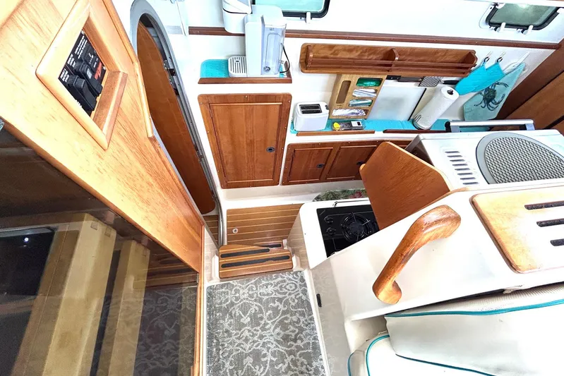 Seahawk Yacht Photos Pics Interior of 2004 PDQ 34 Power Catamaran with wooden cabinetry and compact kitchen area.
