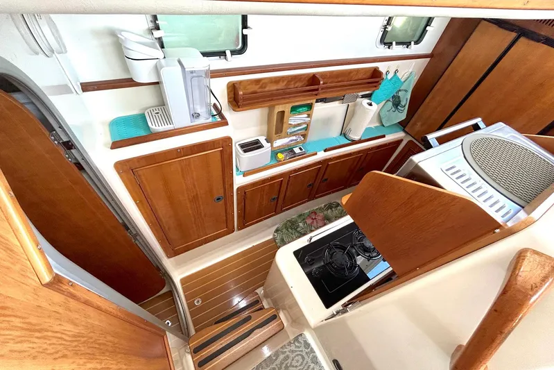 Seahawk Yacht Photos Pics Interior of 2004 PDQ 34 Power Catamaran kitchen with wooden cabinets and appliances.