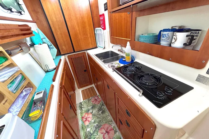 Seahawk Yacht Photos Pics Galley kitchen in 2004 PDQ 34 Power Catamaran with stove, sink, and wooden cabinets.