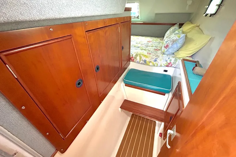 Seahawk Yacht Photos Pics Cozy cabin interior of 2004 PDQ 34 Power Catamaran with wood paneling and floral bedding.
