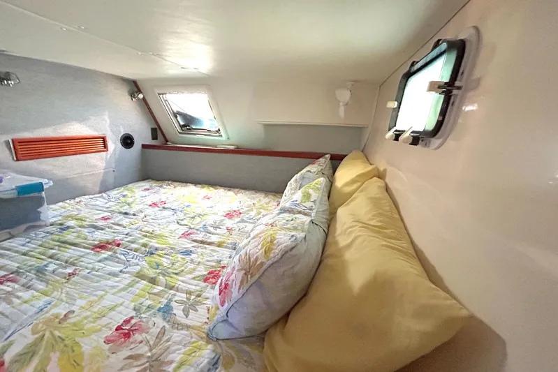 Seahawk Yacht Photos Pics Cozy cabin interior of 2004 PDQ 34 Power Catamaran with floral bedding and porthole windows.