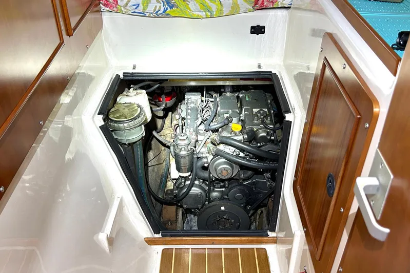Seahawk Yacht Photos Pics Engine compartment of 2004 PDQ 34 Power Catamaran, showcasing mechanical components and wooden cabinetry.