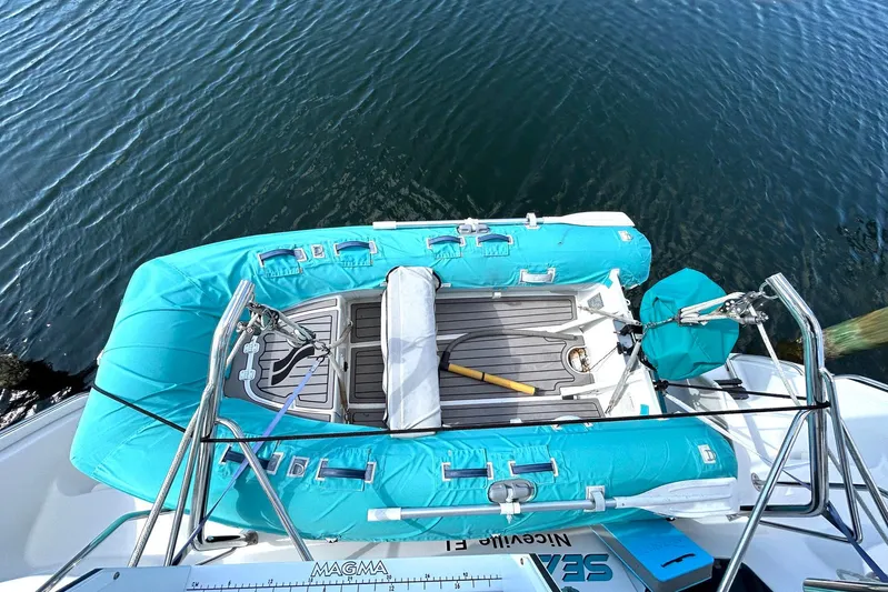 Seahawk Yacht Photos Pics 2004 PDQ 34 Power Catamaran with turquoise inflatable boat on calm water.