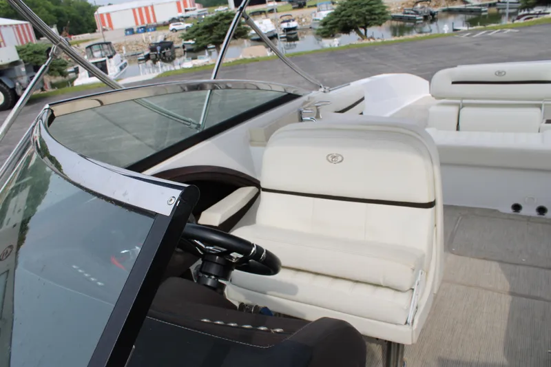  Yacht Photos Pics 2020 Cobalt R30 boat interior with white seating and steering wheel, docked near a marina.