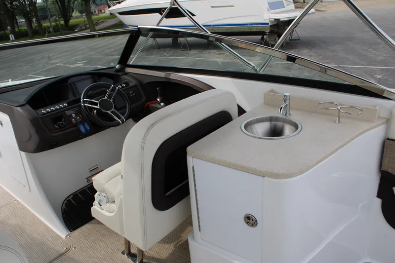  Yacht Photos Pics Interior of a 2020 Cobalt R30 boat featuring a steering wheel and sink area.