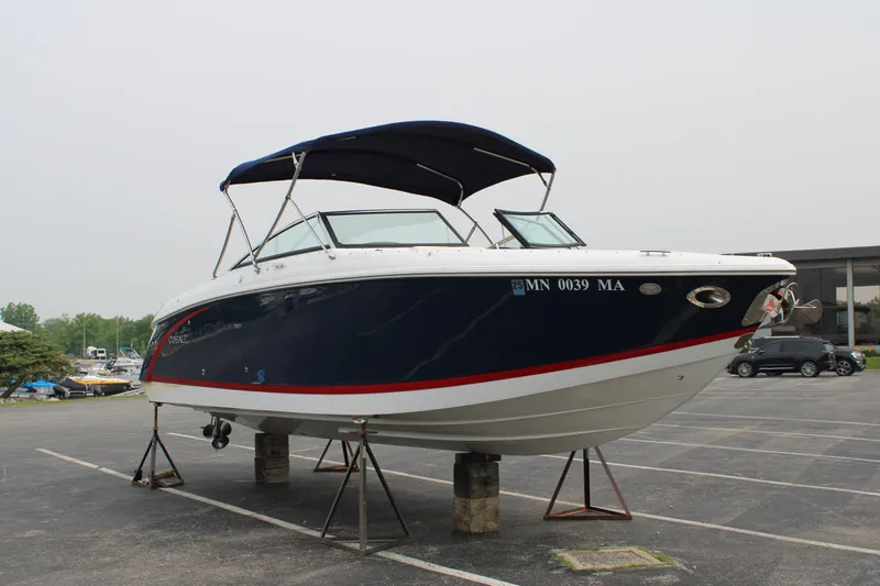  Yacht Photos Pics 2020 Cobalt R30 boat with blue hull and canopy, displayed on stands in a parking lot.