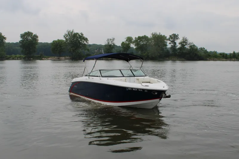  Yacht Photos Pics 2020 Cobalt R30 boat cruising on a calm lake with trees in the background.