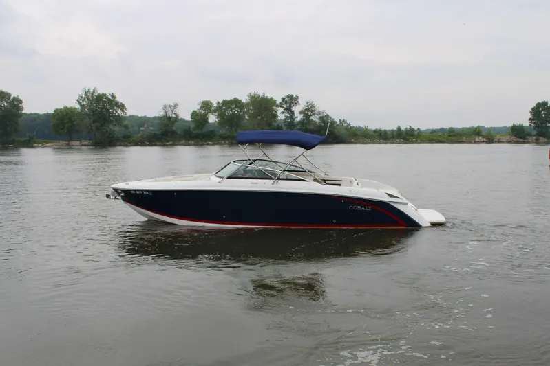  Yacht Photos Pics 2020 Cobalt R30 boat on a calm lake with trees in the background.