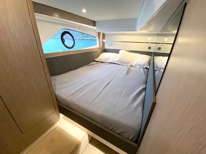 Sealine F430 Yacht Photos Pics 2025 Sealine F430 yacht cabin with cozy bed and porthole view.