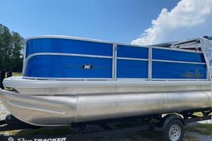 2026 Sun Tracker Party Barge 16 DLX pontoon boat with blue exterior on trailer.