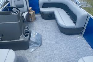 2026 Sun Tracker Party Barge 16 DLX interior with gray seating and console.